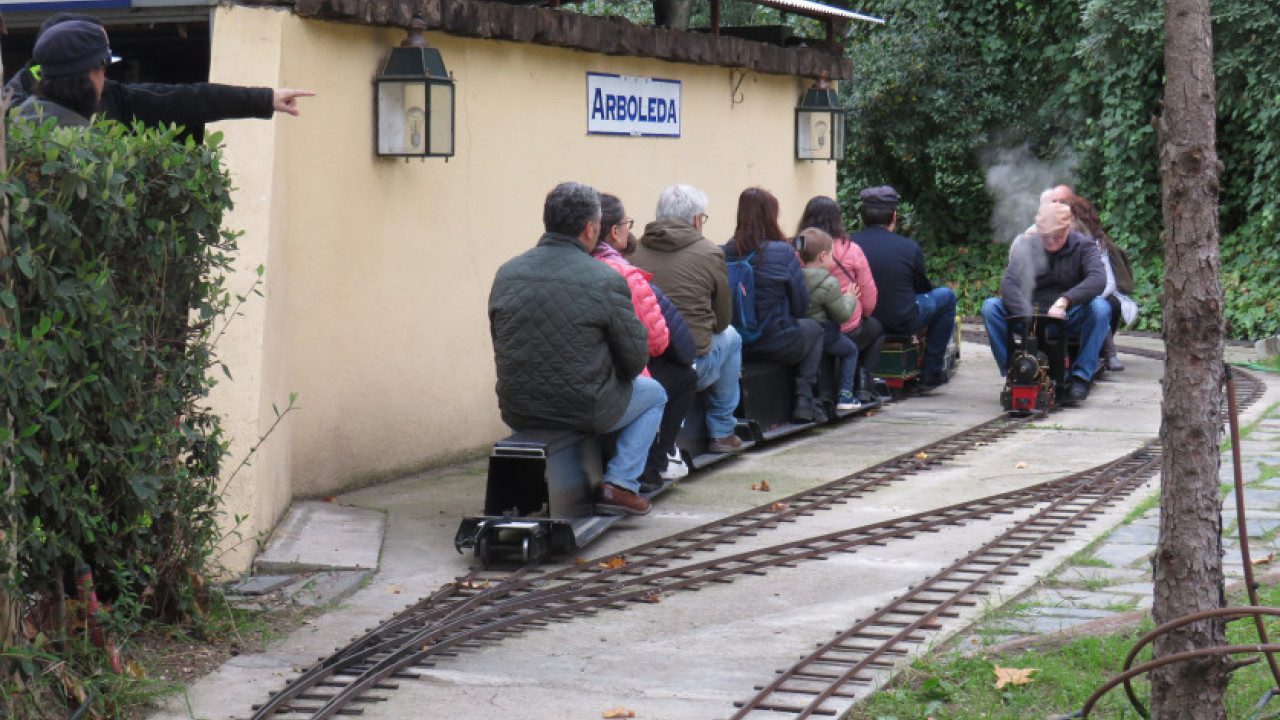 Participantes en la actividad a bordo de dos trenes de jardín en el parque 'Ferrocarril de las Delicias'