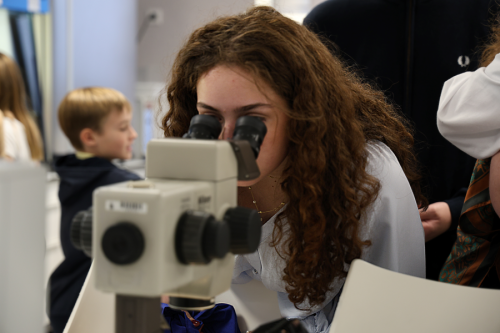 Persona mirando por un microscopio