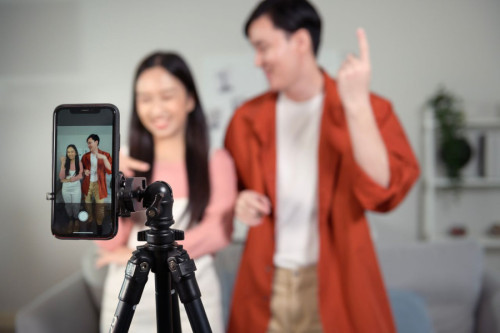Dos jóvenes, hombre y mujer, grabando un TikTok