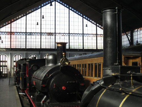 Interior de la estación de Madrid-Delicias, sede del Museo, con algunos vehículos de su exposición en primer plano.