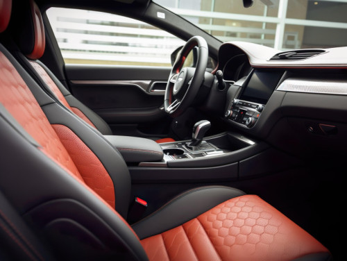 Interior de un coche con tapizado de cuero rojo y negro. Imagen de Ewan en Pixabay