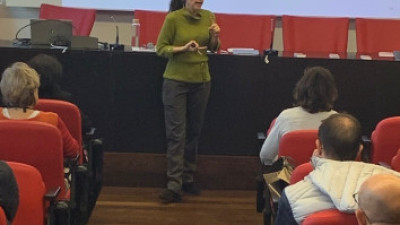 En la imagen, tomada durante una conferencia ofrecida al público asistente, una compañera de AEMET explica la importancia de las colaboraciones de la Agencia con organismos internacionales.